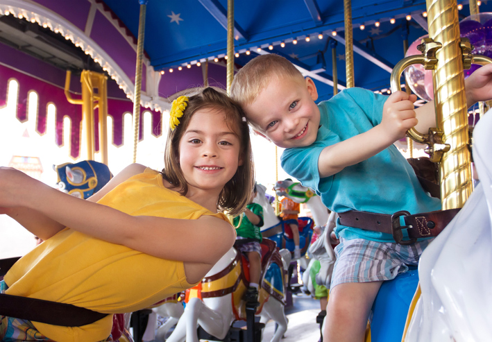 kids having fun riding carousel in one of the amusement parks near Indian Rock Beach