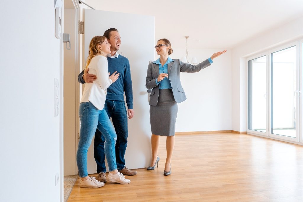 Realtor showing house to a young couple